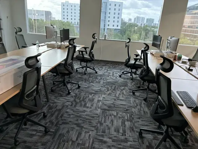 Creating a Finished Workplace in Miami Modern office workspace with ergonomic chairs, computer monitors, and large windows overlooking city buildings