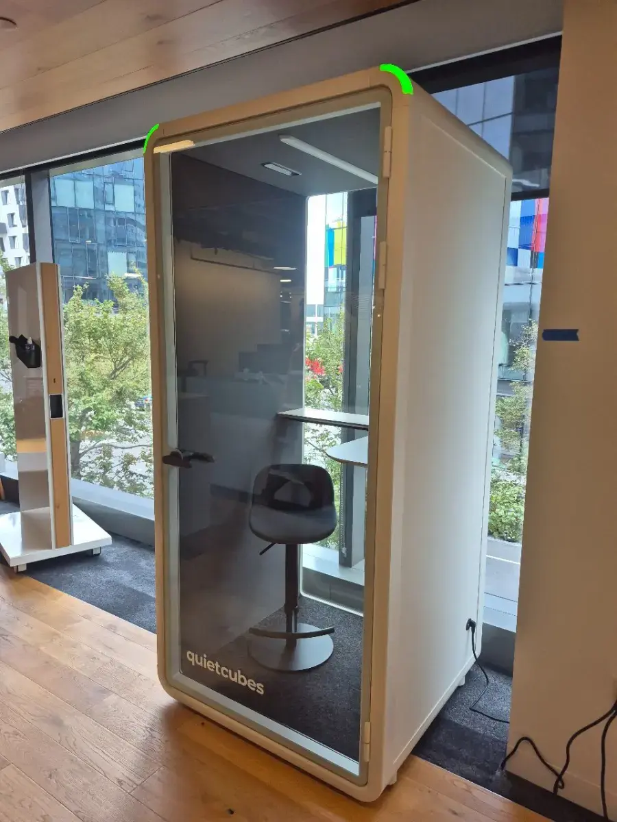 Contact Us Private office phone booth with padded chair, curved desk, and LED indicator lights for work