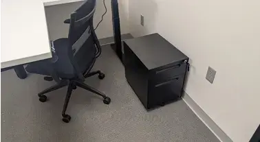 Kansas City, MO: Primary Care Office Furniture Installation Creates a Professional Patient Environment Black mesh office chair beside a filing cabinet and white desk