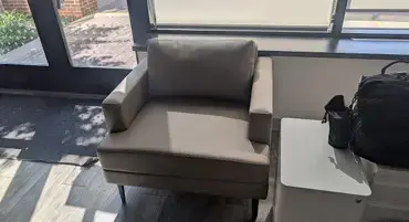 Kansas City, MO: Primary Care Office Furniture Installation Creates a Professional Patient Environment Gray armchair beside a white side table near large windows