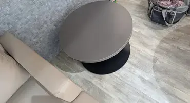 Kansas City, MO: Primary Care Office Furniture Installation Creates a Professional Patient Environment Round gray coffee table beside a beige sofa in a lounge